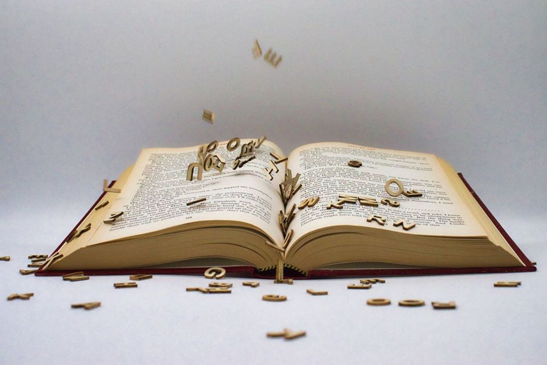 Раскиданные наборные буквы у раскрытой книги — сербский алфавит приходится осваивать дважды